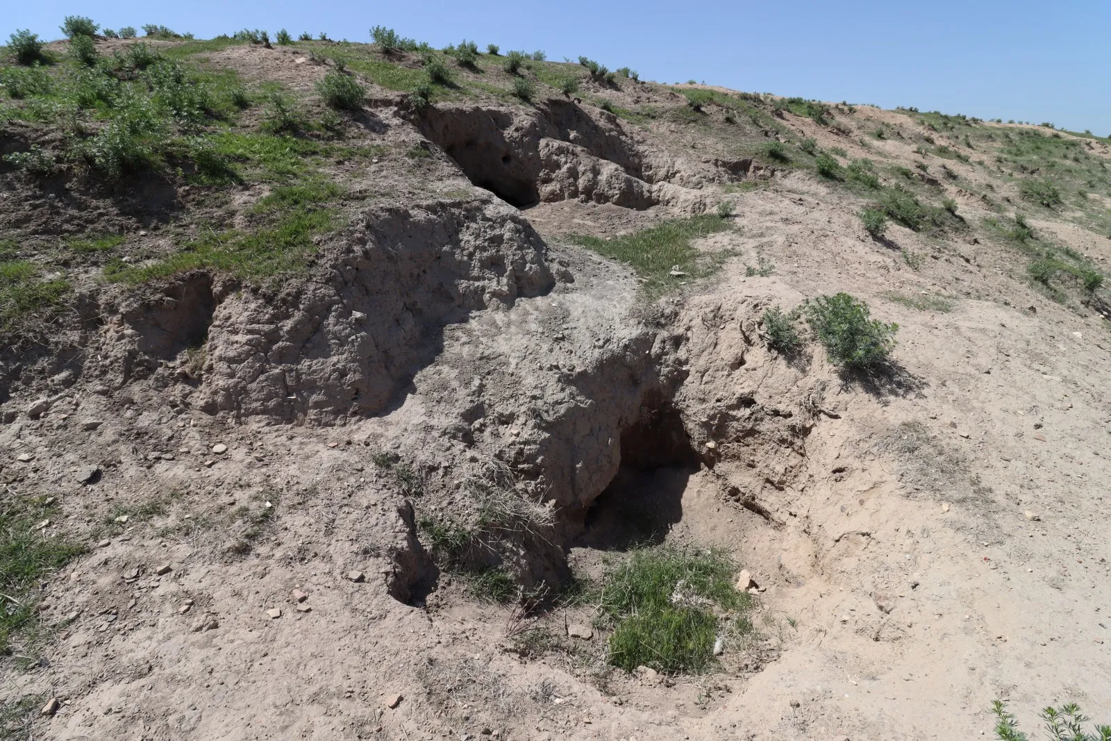 Höyük yamacındaki kazı çukurları