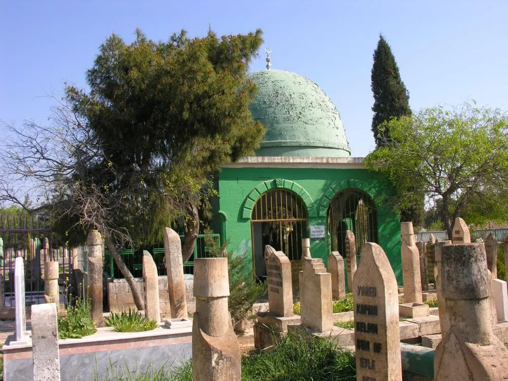 Mezar taşları arasında yeşil kubbeli türbe