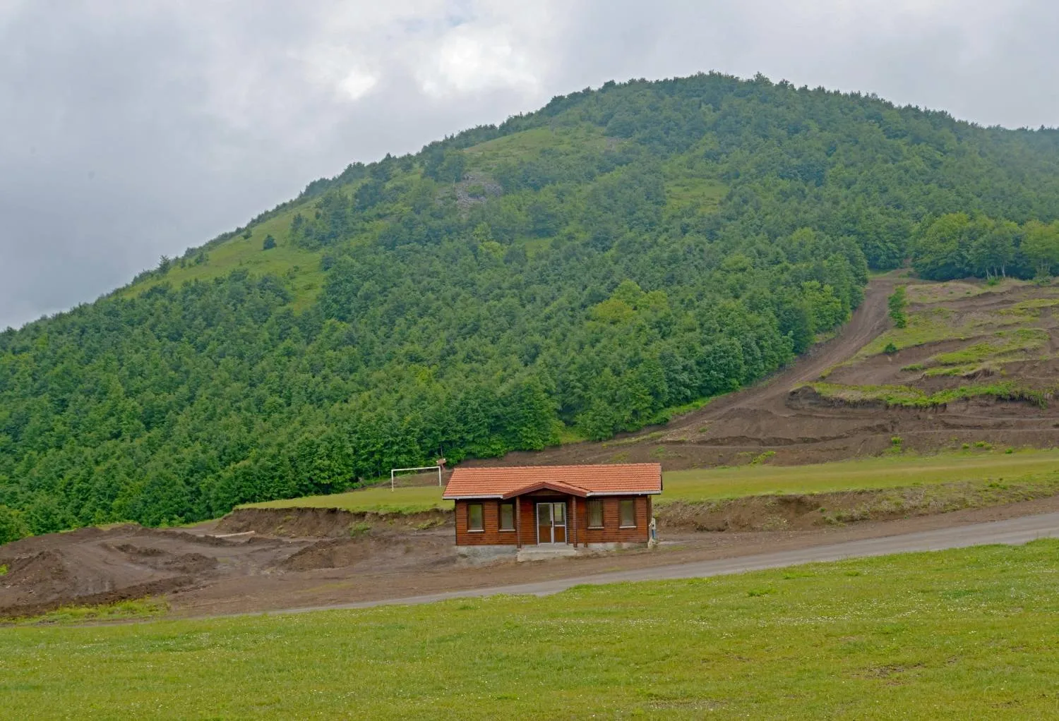 Suadiye Tabiat Parkı'nda ahşap bina ve yeşil tepe