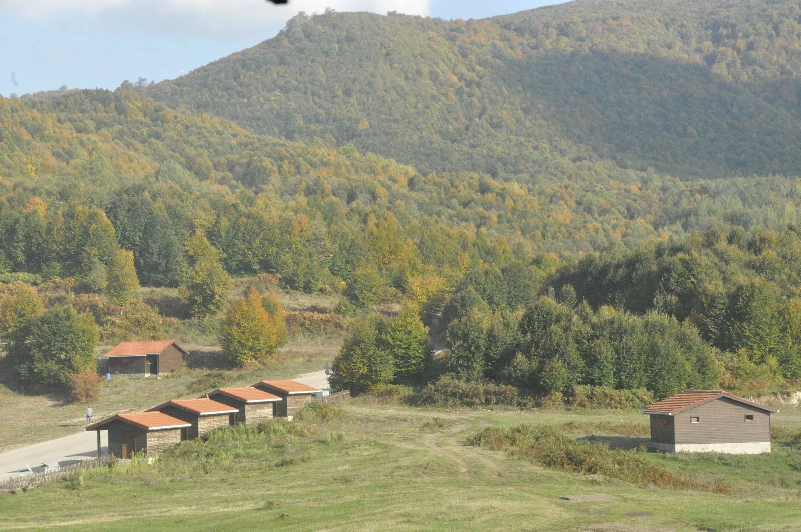 Suadiye Tabiat Parkı vadisinde ahşap yapılar ve ormanlık dağlar